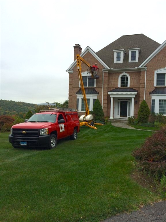 Home inspector on crane looking at home
